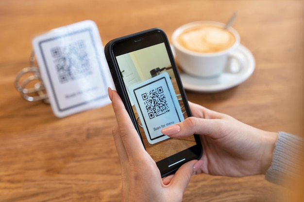 Close up hands scanning qr code with smartphone