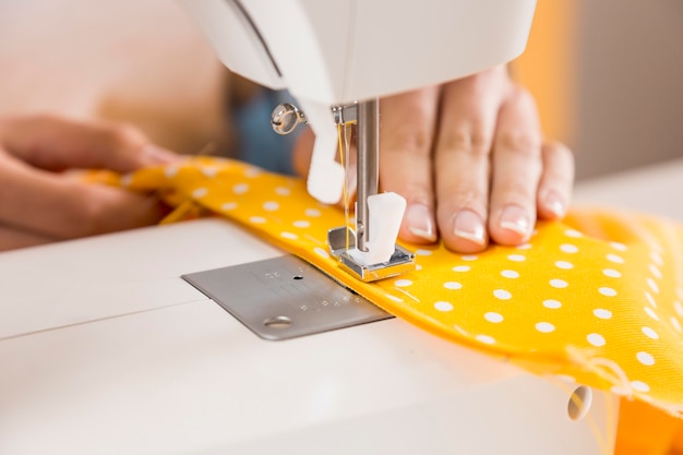 Close-up hands sewing with machine