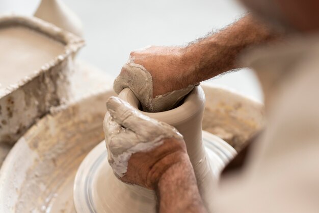 Close up hands shaping clay