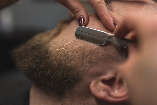 Close-up hands shaving man