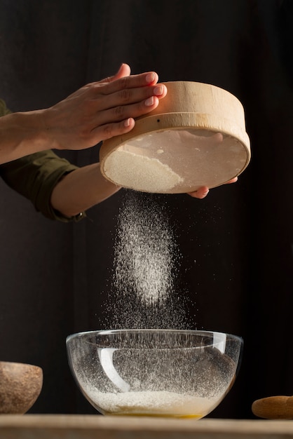 Free photo close up hands sifting flour