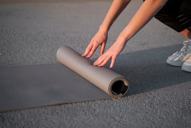 Free photo close up hands spreading yoga mat