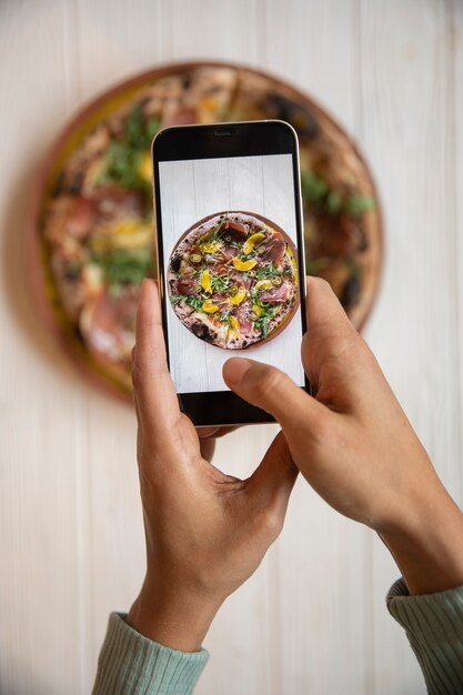 Close up hands taking pizza photo