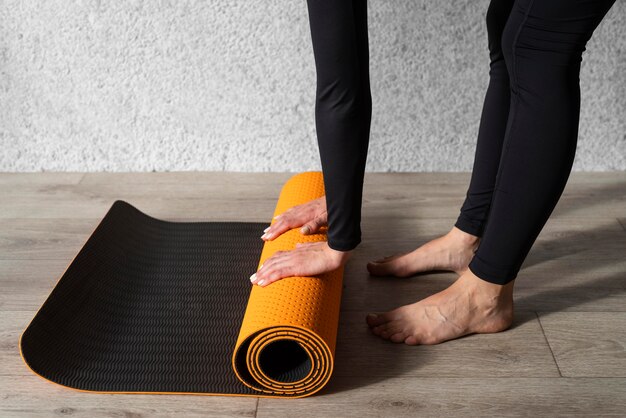 Close-up hands touching yoga mat