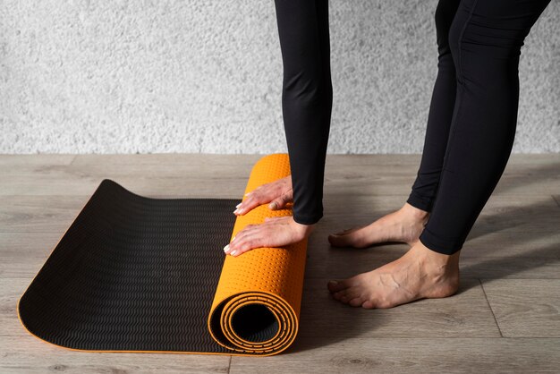 Руки крупным планом касаются коврика для йоги