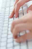 Foto gratuita primo piano di mani digitando sulla tastiera sul posto di lavoro