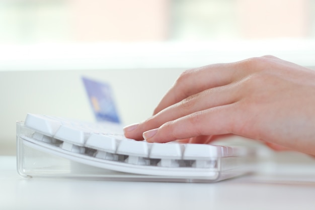 Primo piano di mani digitando sulla tastiera sul posto di lavoro