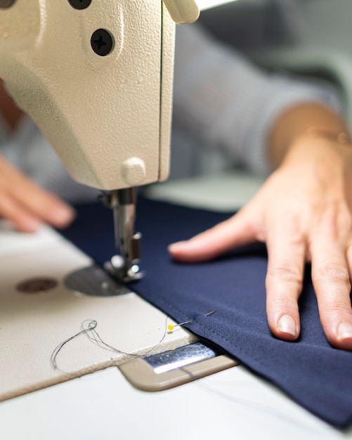 Close-up hands using sewing machine