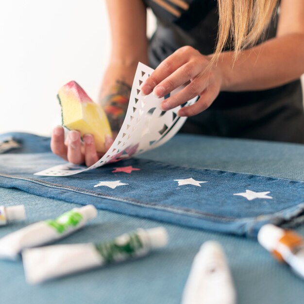 Close-up hands using sponge to paint