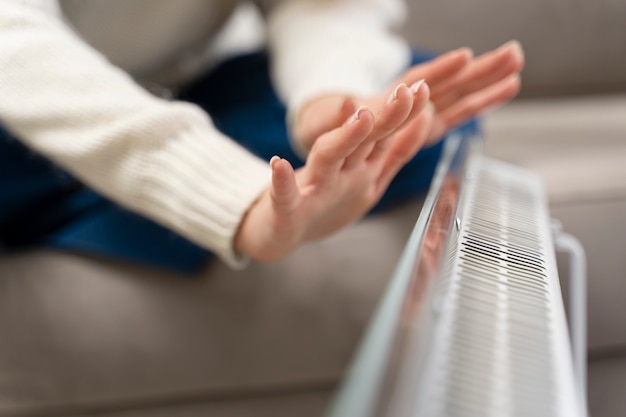 Free photo close up hands warming up near heater