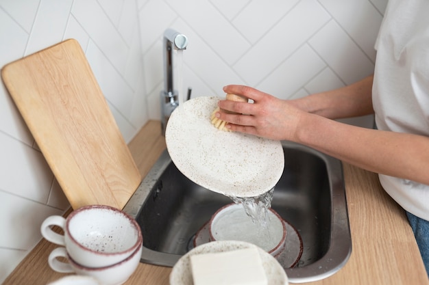 Free photo close up hands washing dishes