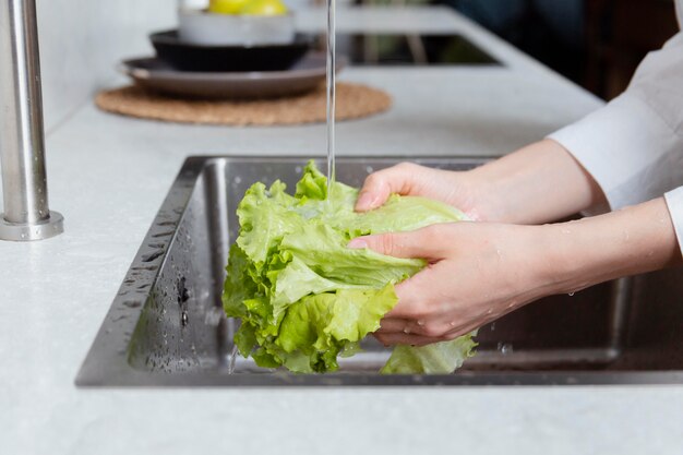 Close up hands washing lettuce