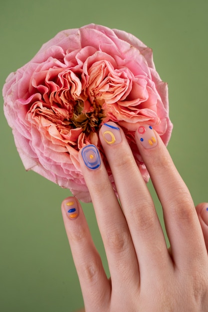 Free photo close up hands with beautiful manicure and flower