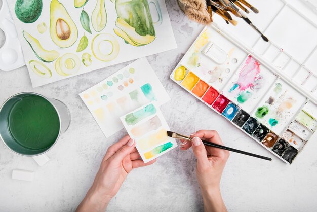 Close-up hands with brush and watercolors