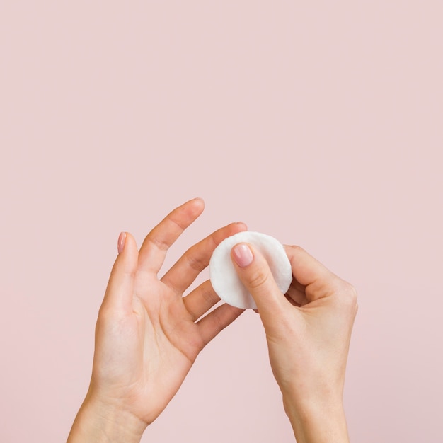 Close-up hands with cotton disc