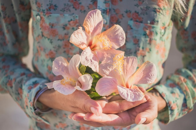 Foto gratuita primo piano delle mani con i fiori