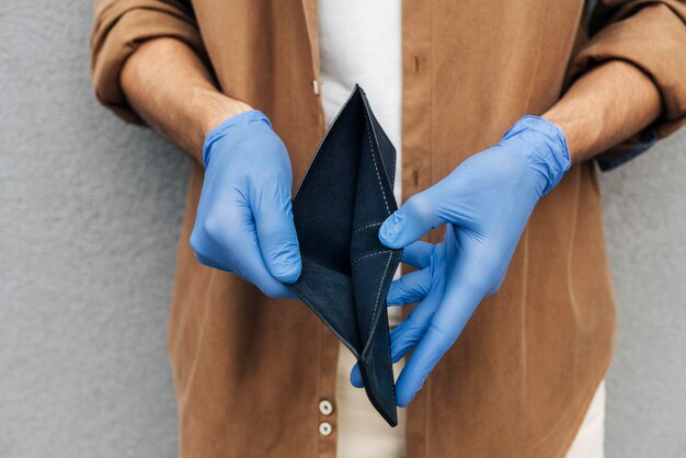 Close-up hands with gloves holding wallet