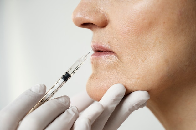 Close up hands with gloves injecting woman