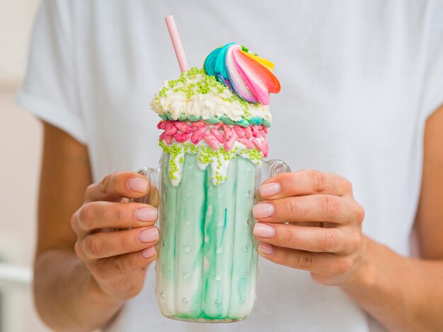 Макро руки с зеленым молочный коктейль