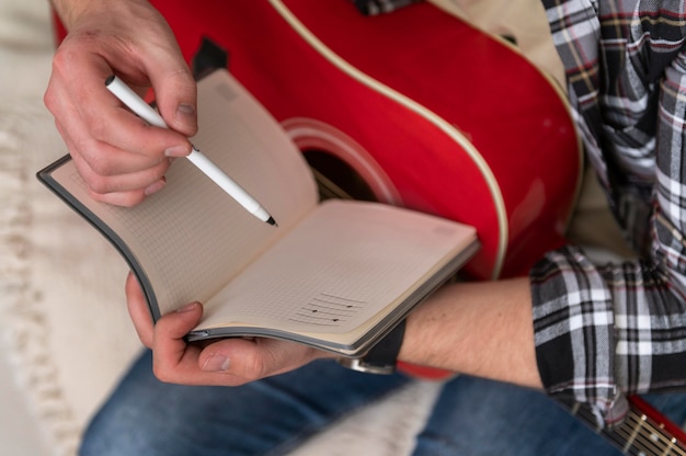 Close up hands with notebook and guitar