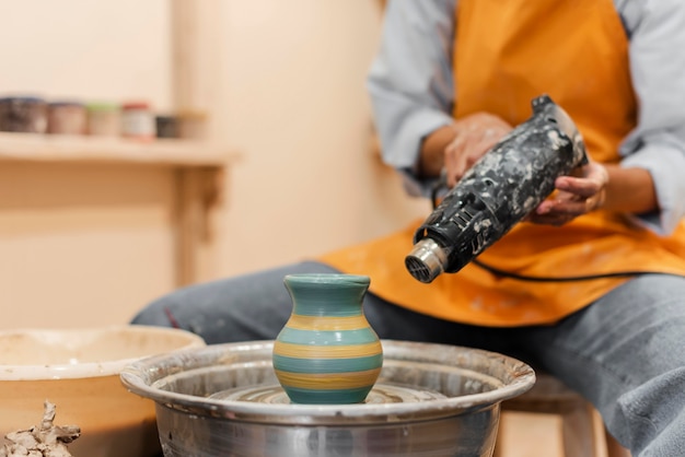 Close up hands with pottery device