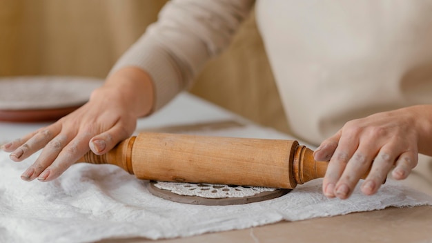 Close-up hands with rolling pin