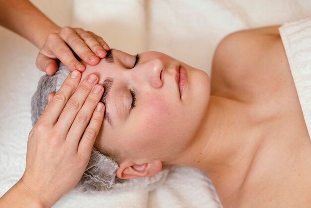 Close up hands on woman forehead