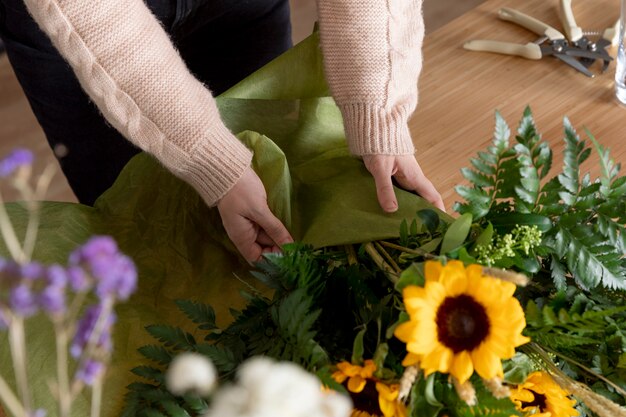 Close up hands wrapping flowers