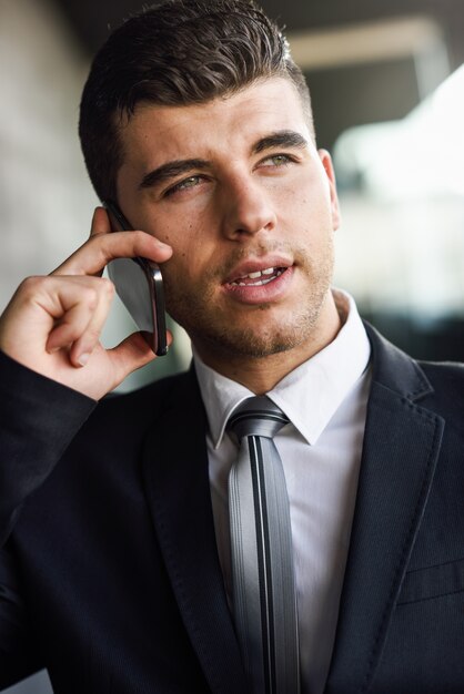 Close-up of handsome employee talking on the cellphone