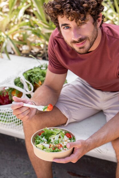 Close up on handsome man eating in park