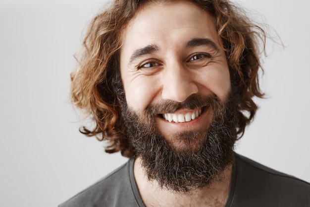 Крупный план красивого улыбающегося бородатого ближневосточного человека счастливым