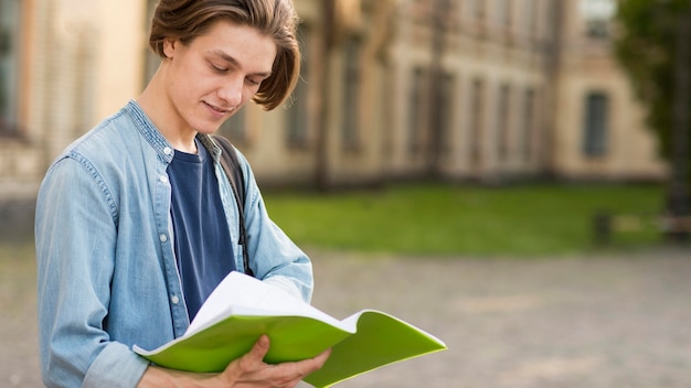 Close-up handsome student readying notes