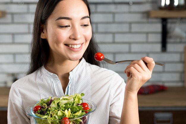 건강 한 샐러드를 먹는 행복 한 아시아 여자의 근접 촬영