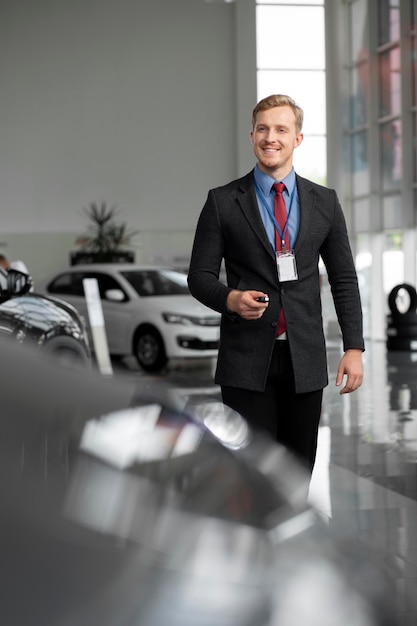 Foto gratuita primo piano su un uomo d'affari felice in una concessionaria di auto