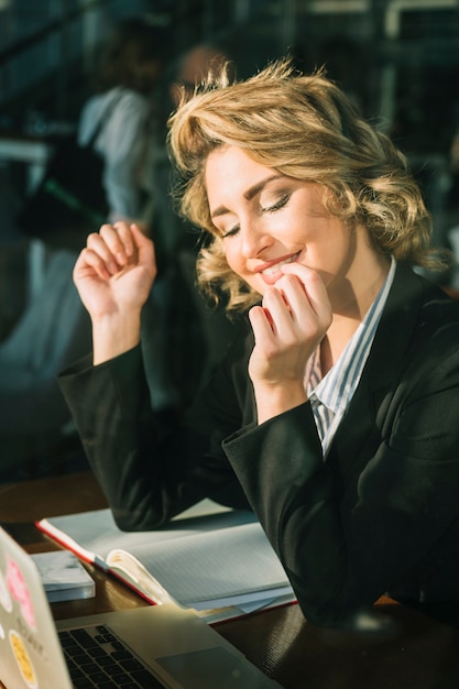 Close-up of a happy businesswoman sitting in restaurant