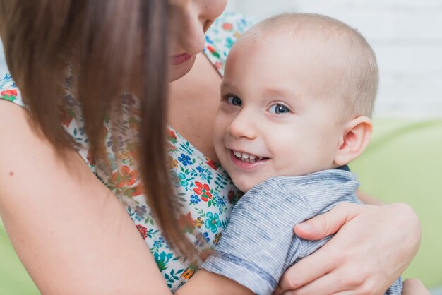 Close-up of happy child in his mother's arms