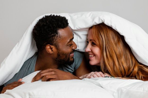 Close-up happy couple under blanket