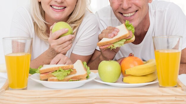 Close-up happy couple eating together