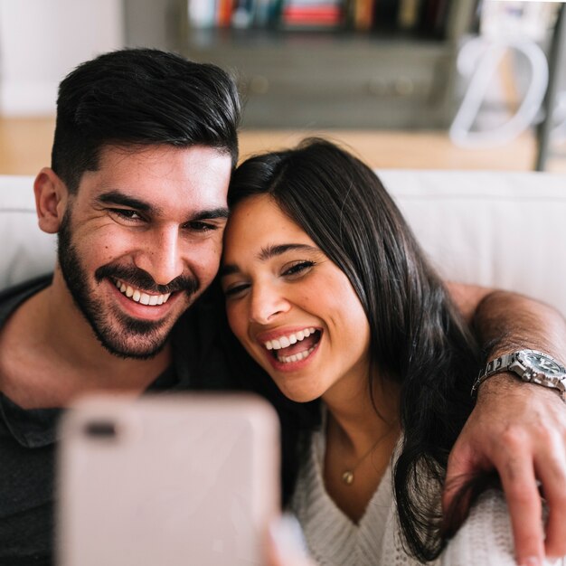 Close-up of happy couple taking self portrait of cellphone