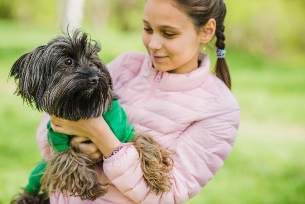 彼女の犬を見て幸せな女の子のクローズアップ