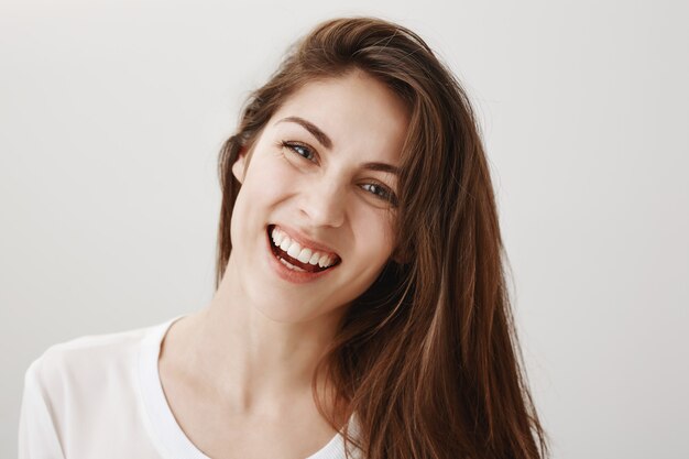 Close-up of happy gorgeous healthy woman smiling and laughing at front