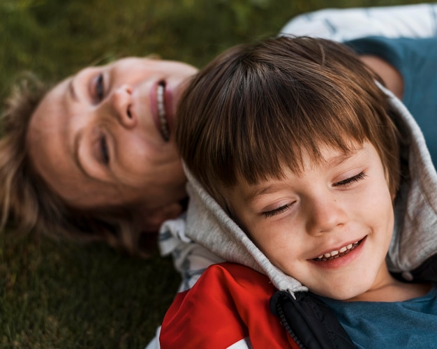 Close-up happy kid and woman on grass