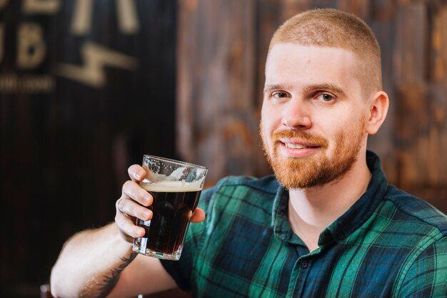 Close-up of a happy man drinking beer