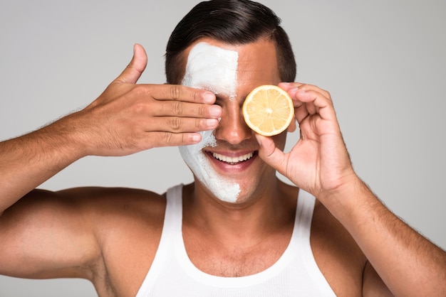 Close-up happy man holding lemon half