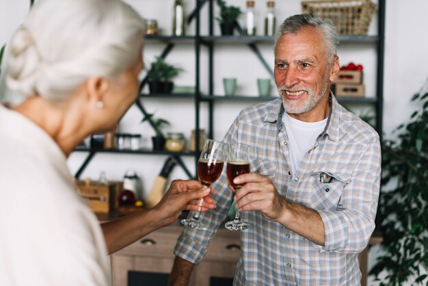 Close-up of happy senior couple toasting wine glasses