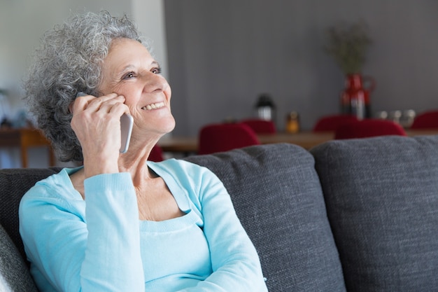 Close-up of happy senior woman talking on smartphone