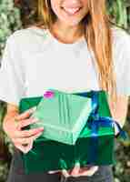 Free photo close-up of a happy woman holding green gift boxes