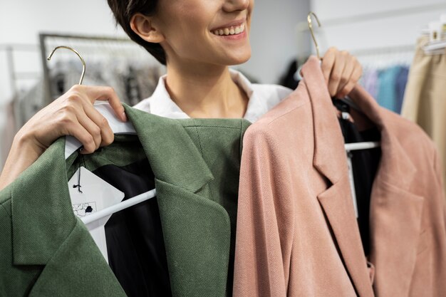 Close up happy woman holding hangers