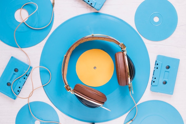 Close-up headphones amidst discs and cassettes
