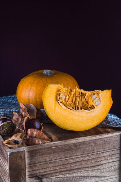 Close-up of a healthy chestnut and ripe pumpkin on wooden table